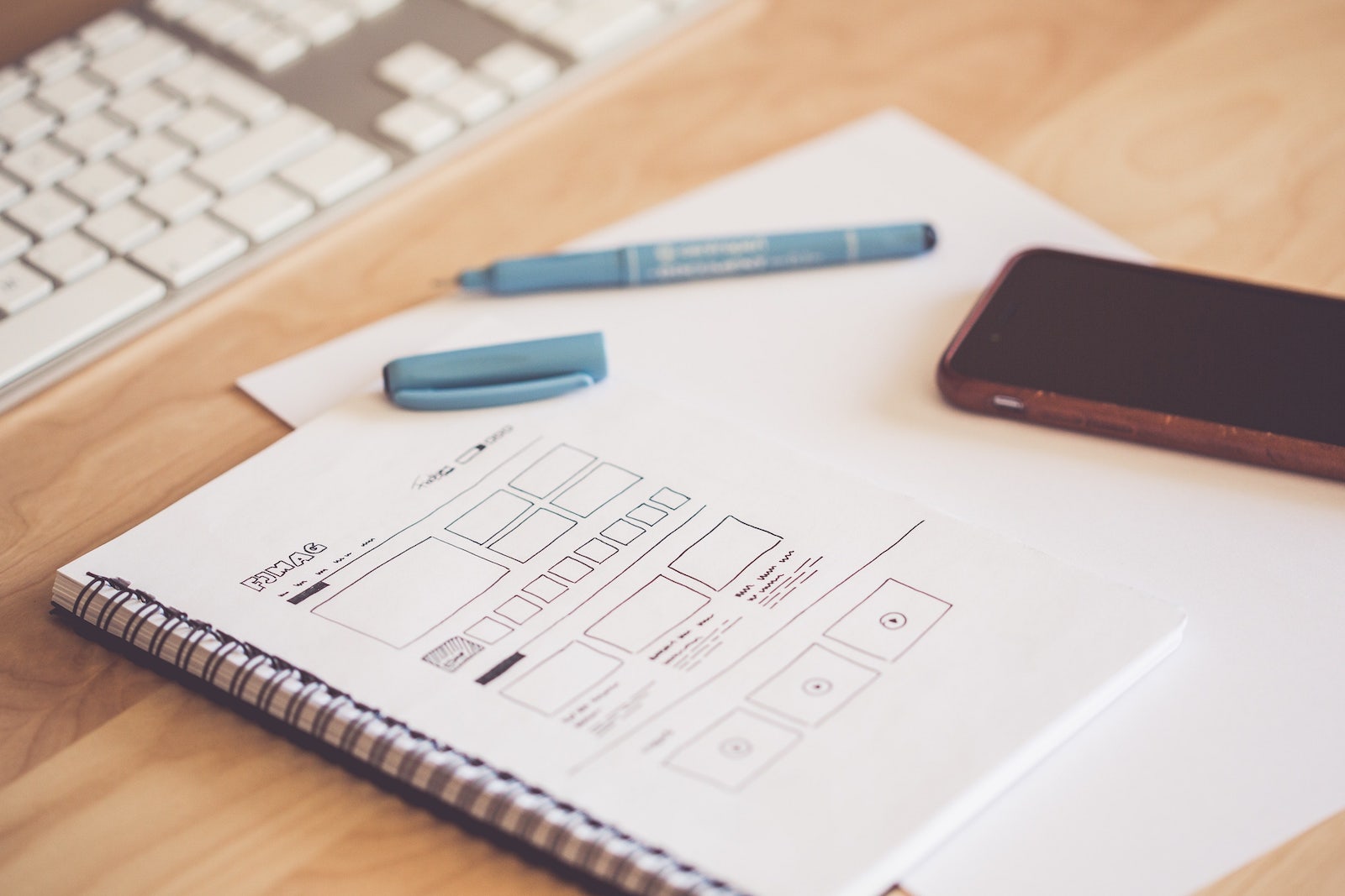 a notebook with a wireframe drawing of a website design